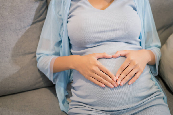 primer plano de la belleza feliz mujer embarazada asiática con gran vientre por ventana embarazo, maternidad, personas y concepto de expectativa
. - Foto, Imagen