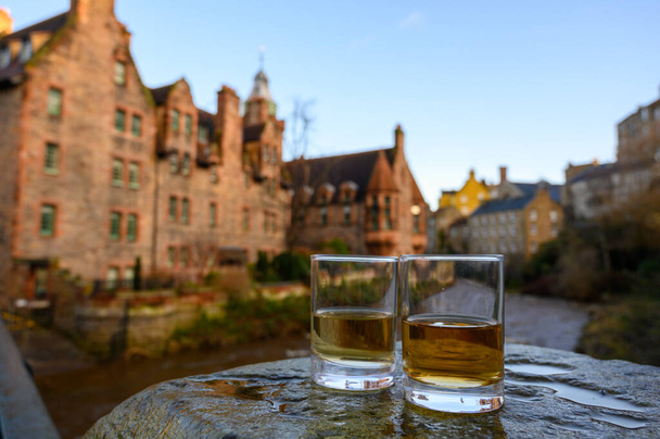 Scotch single malts or blended whisky spirits in glasses with old houses of Edinburgh city on background, Scotland, UK - Photo, Image