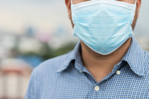 Close up young asian man wearing protection face mask against coronavirus. - Photo, Image