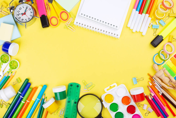 Various school office and painting supplies on yellow background. Back to school concept. Top view. Copy space - Foto, imagen