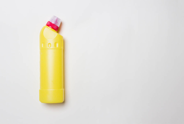bouteille jaune avec agent nettoyant sur fond de papier coloré avec espace de copie. - Photo, image