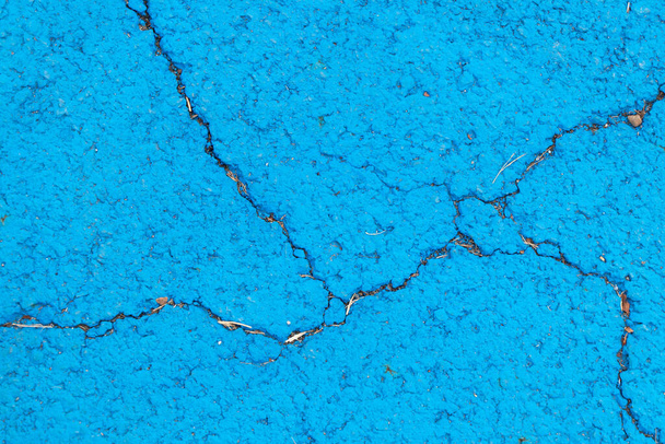 Blue color painting in cracked concrete textured background - Photo, Image