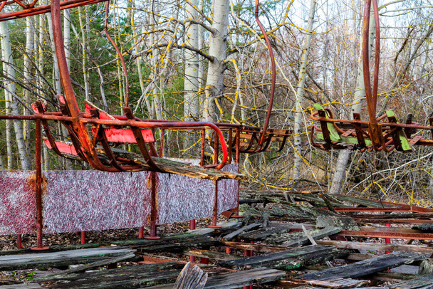 Abandoned carousel at an amusement park in the center of the city of Pripyat, the Chernobyl disaster, the exclusion zone, a ghost town - Foto, imagen