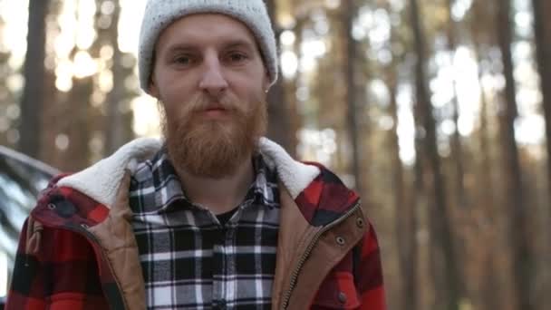 Середній постріл з імбирного волосся бородатого молодого чоловіка, що стоїть на машині і вивчає карту на лісовій дорозі
 - Кадри, відео
