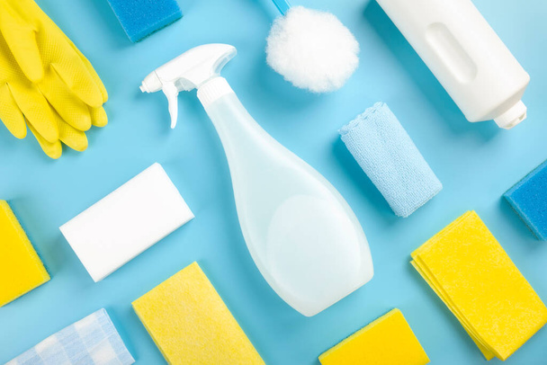 Detergents and cleaning products agent, sponges, napkins and rubber gloves, blue background. Top view - 写真・画像