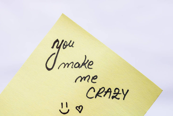 You make me crazy handwriting text close up isolated on yellow paper with copy space. - Photo, Image