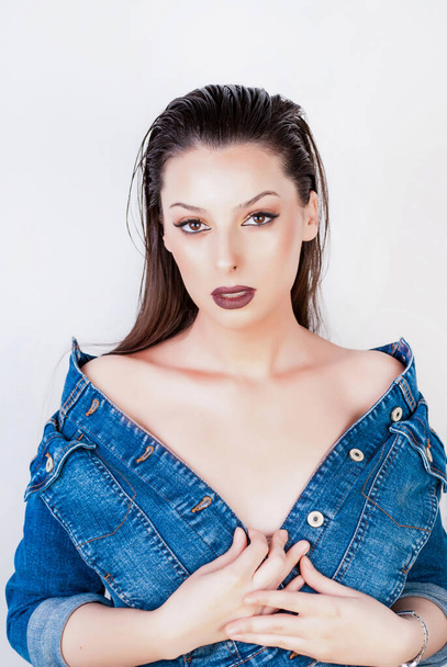 Young beautiful girl with wet jacket and opened blue jeans jacket on white background - Valokuva, kuva