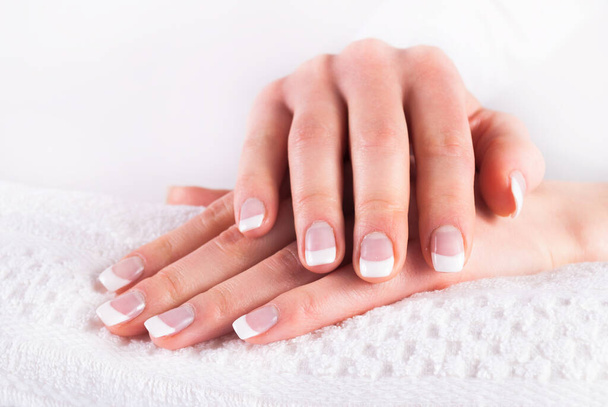 Mains avec manucure ongles français sur serviette blanche - Photo, image