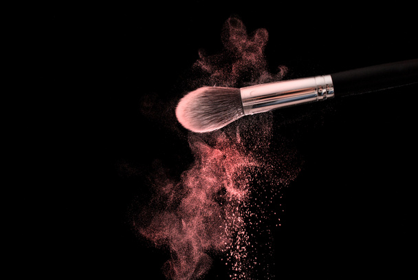 Maquillaje cepillo con polvo rojo explosión nube, enfoque selectivo, de cerca
 - Foto, Imagen