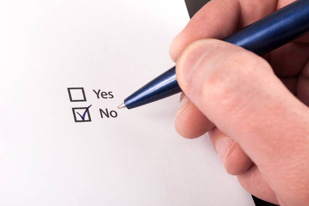 Check boxes with yes and no question, hand with pen check no. Close up - Photo, Image