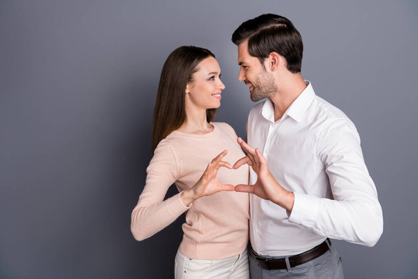 Photo beautiful lady handsome guy couple stand close hugging making heart figure hands fingers celebrating anniversary look eyes tender wear shirt pullover isolated grey color background - 写真・画像