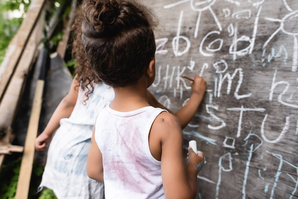 back view of poor african american kids near chalkboard  - Photo, Image
