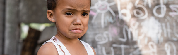 panoramic concept of poor african american boy crying near chalkboard  - Photo, Image