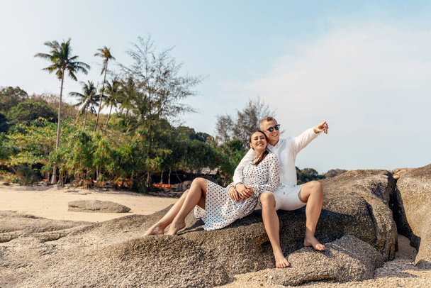 Attractive young couple sitting on the beach - Фото, зображення