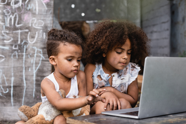 foyer sélectif des enfants afro-américains pauvres utilisant un ordinateur portable à l'extérieur  - Photo, image