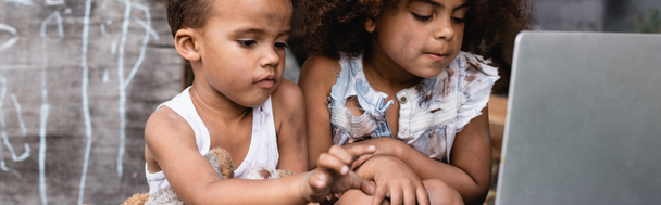 panoráma termés szegény afro-amerikai gyerekek nézi laptop kívül  - Fotó, kép
