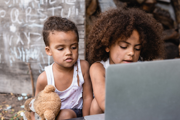 szelektív fókusz szegény afro-amerikai gyerekek nézi laptop kívül  - Fotó, kép