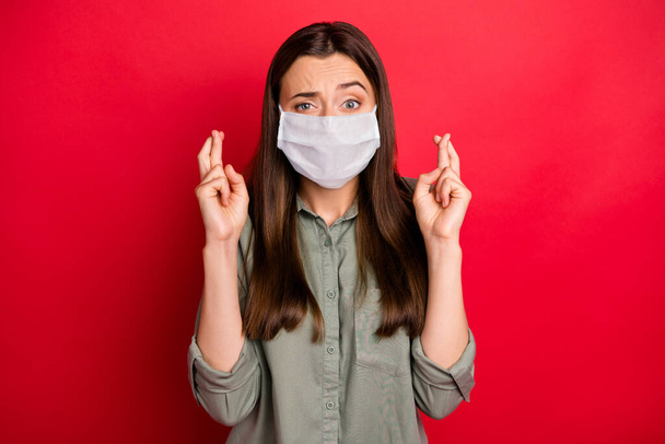 Close-up portrait of her she worried girl wearing safety mask waiting news mers cov influenza infection medicine test diagnosis crossed fingers isolated bright vivid shine vibrant red color background - Foto, afbeelding