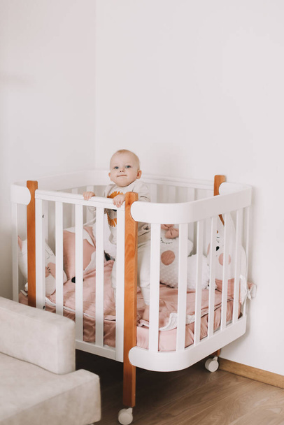 Cute little baby standing in crib at home. - Fotoğraf, Görsel