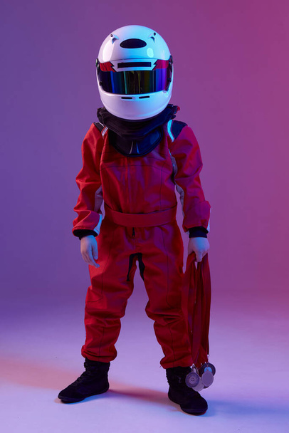 Cool boy child racer in helmet with medals, standing in neon light. Kart racing school poster. Competition announcement - Zdjęcie, obraz