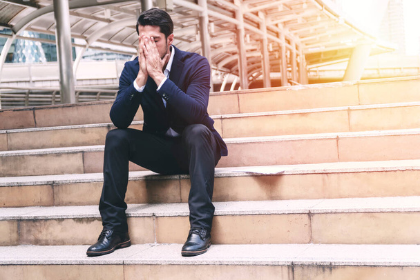 Liikemies konkurssin ja velan kädet peittävät kasvot istuessaan portailla.Työttömät liikemiehet turhautunut ja epätoivoinen löytää työtä. Käsite yrittäjien epäonnistuminen ja työttömyysongelma - Valokuva, kuva