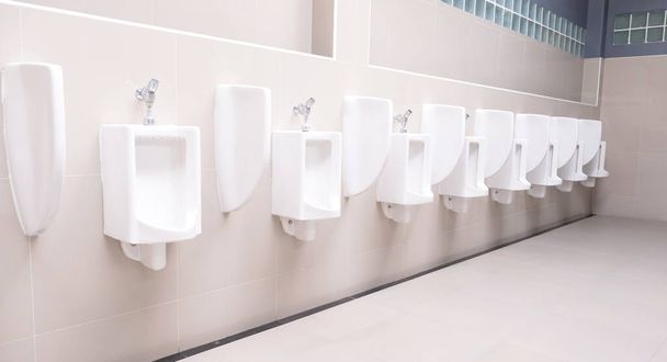 Pánské WC veřejnost s bílým porcelánu pisoáry stánek, Moderní čistá koupelna na čůrání. - Fotografie, Obrázek
