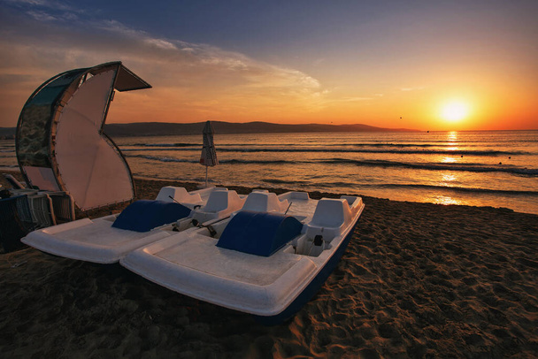 Due catamarani sulla spiaggia. Spiaggia sabbiosa al tramonto. Gite in barca su un catamarano - Foto, immagini