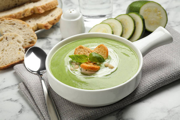 Tasty homemade zucchini cream soup served on marble table - Foto, imagen