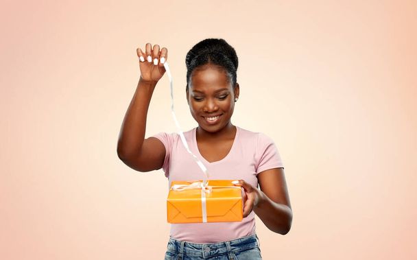 happy african american woman with gift box - Фото, изображение
