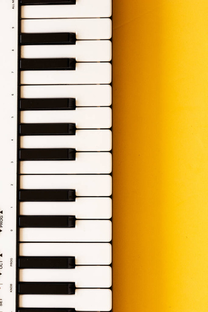 Controlador de piano MIDI pequeo sobre fondo amarillo. Estudiando música en casa
 - Foto, Imagen