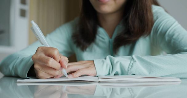 Γυναίκα γράψει στο σημειωματάριο στο σπίτι - Φωτογραφία, εικόνα