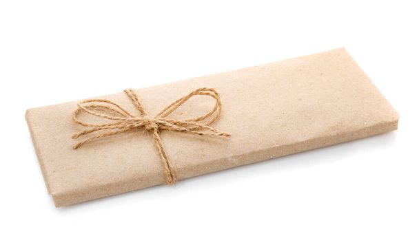 Box wrapped in kraft paper and with burlap ribbon on a white background. - Photo, Image