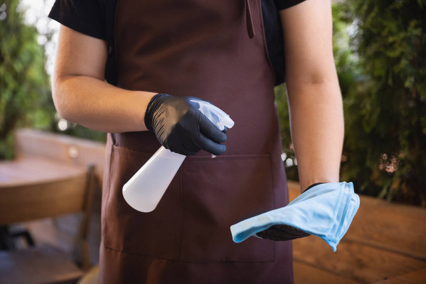 El camarero trabaja en un restaurante con una máscara médica, guantes durante la pandemia de coronavirus
 - Foto, imagen