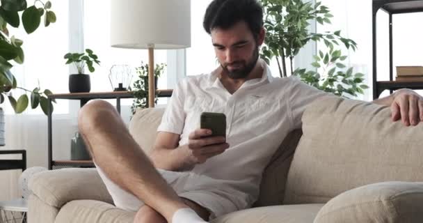 Man using mobile phone at home - Video, Çekim