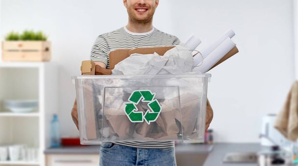 smiling young man sorting paper waste - Zdjęcie, obraz