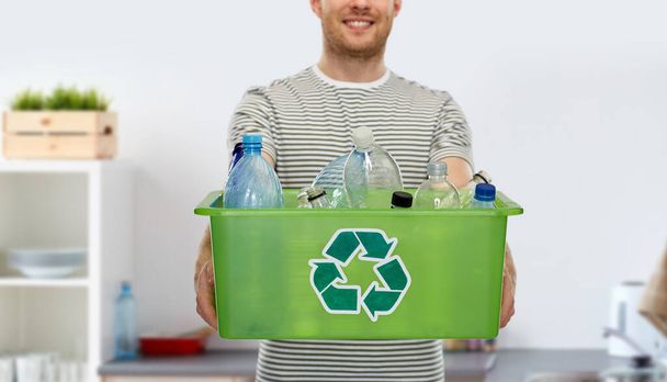 smiling young man sorting plastic waste - Foto, imagen