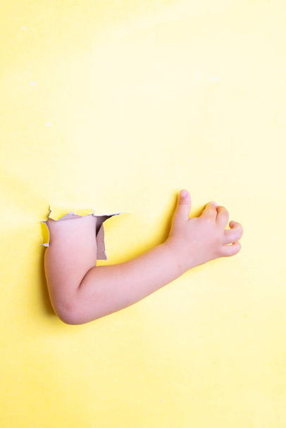 Hand toont een duim omhoog op geel papier, verticale foto. Plaats voor tekst - Foto, afbeelding