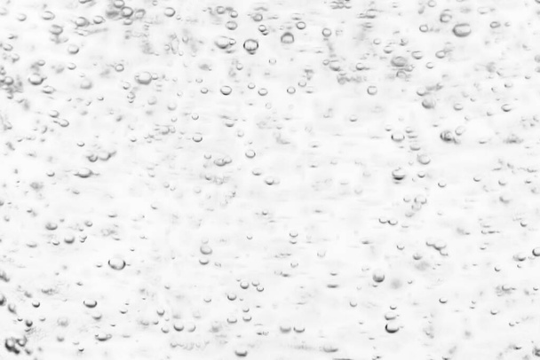 Monochrome background with air bubbles in the liquid. Carbonated drinks. Abstract backdrop for design. - Photo, image