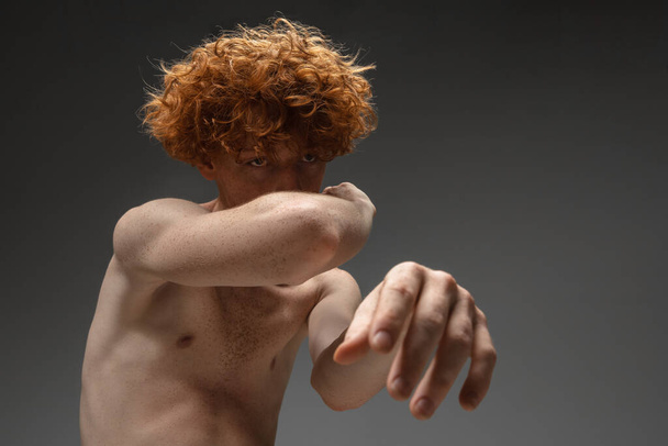Portrait of beautiful redhead man isolated on grey studio background. Concept of beauty, skin care, fashion and style - 写真・画像