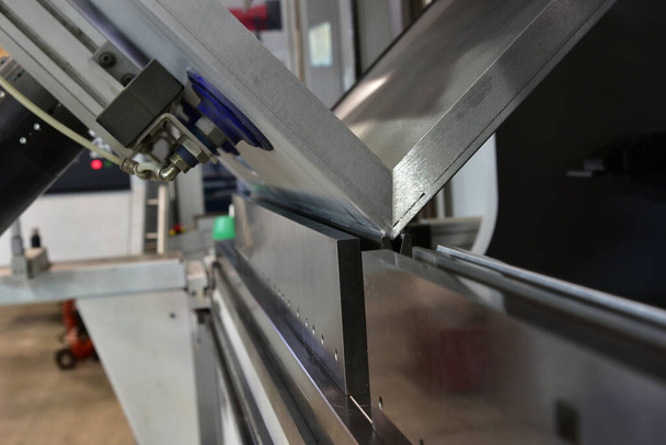 Metal levhaları kağıt bükme makineleriyle büken operatör. - Fotoğraf, Görsel