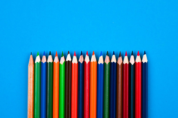 Crayons multicolores sur fond bleu. Photo de haute qualité - Photo, image