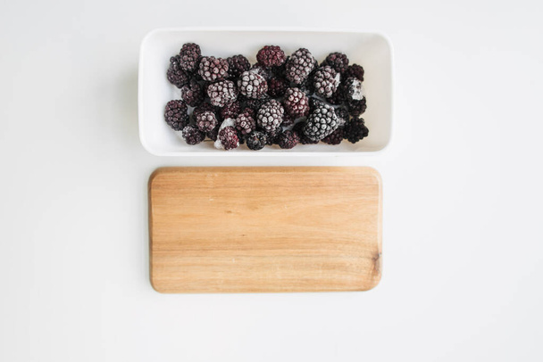 frozen blackberries in a lunch box on white background - Fotografie, Obrázek