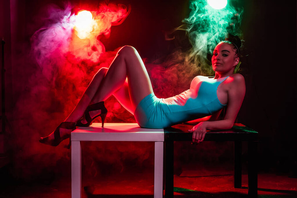 Mulher com maquiagem na moda em luzes brilhantes coloridas com fumaça - imagem de estoque
 - Foto, Imagem