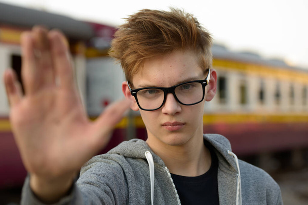 Portrait of young handsome teenage boy at the railway train station - Φωτογραφία, εικόνα