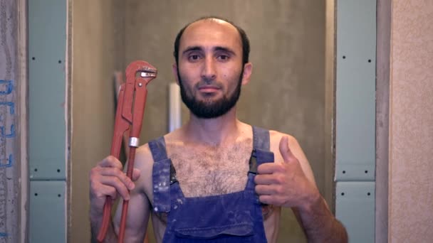 Άντρας υδραυλικός δείχνει τον αντίχειρα. Προσωπογραφία ενός Ασιάτη υδραυλικού σε εσωτερικούς χώρους - Πλάνα, βίντεο