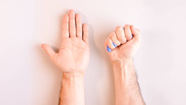 Imagen 9 de una secuencia de imágenes en las que las manos de un hombre se quitan los guantes desechables azules médicos. Vista superior. Enfoque selectivo
 - Foto, imagen