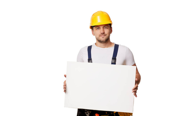 repairman in uniform holding empty blank board. - Fotoğraf, Görsel