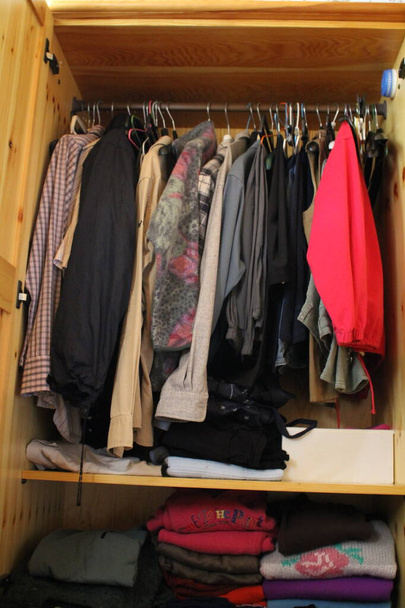 fa szekrény tele ruhák, zsúfolt szekrény - Fotó, kép