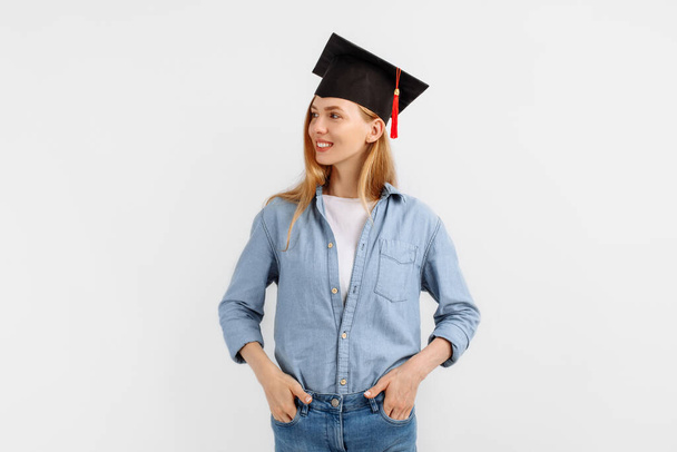 Happy confident girl graduate with a graduation hat on her head, on an isolated white background - Fotografie, Obrázek