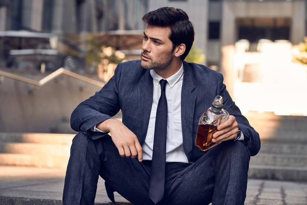 Depressziós üzletember, aki whiskyt iszik egy üvegből. A férfit kirúgták.. - Fotó, kép